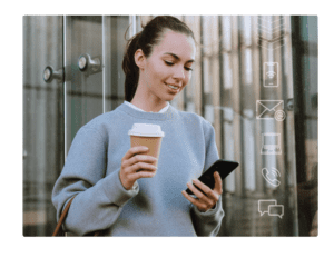 Woman holding a coffee and looking at her cell phone.