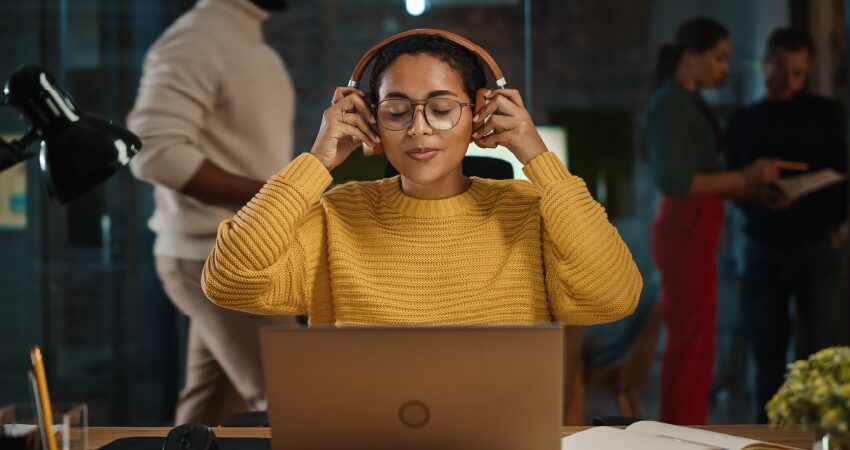 Woman listening to headphones at computer